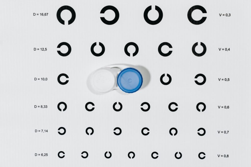 Image of a contact lens case on top of generic eye chart